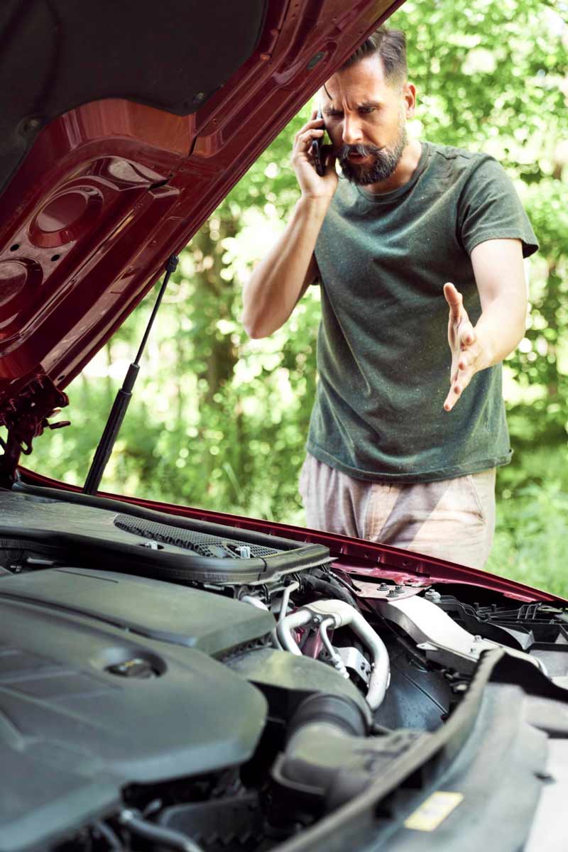 Junger Mann prüft Getriebeschaden bei Schrottauto Ankauf Vreden